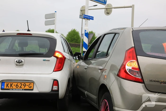 Twee auto's botsen op rotonde
