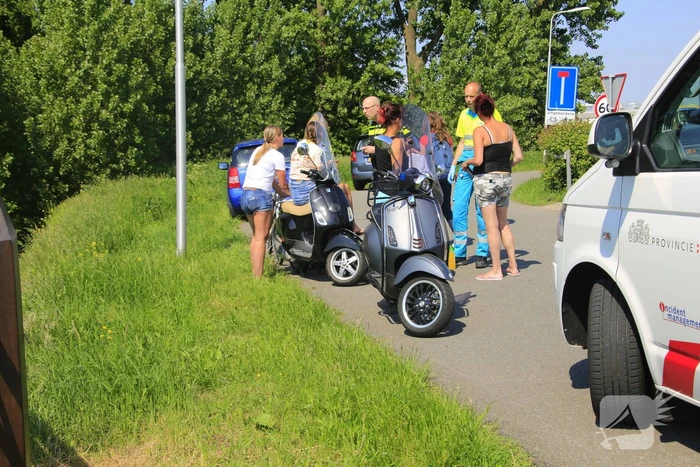 Fietsster en scooterrijdster botsen