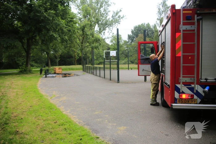 Brandweer blust aangestoken pallets