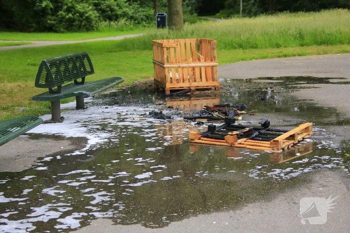Brandweer blust aangestoken pallets