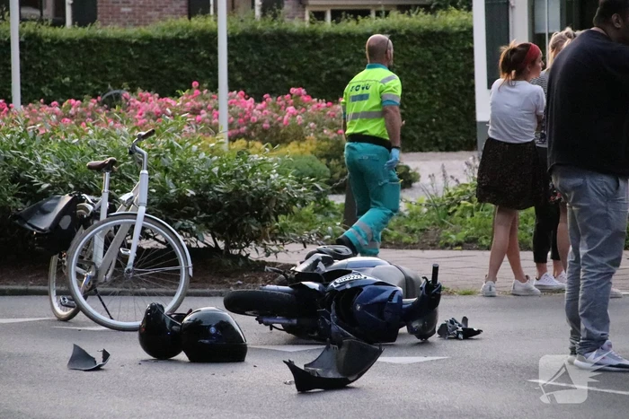 Scooter geschept door auto, twee gewonden