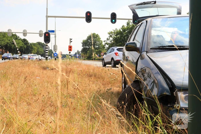 Automobilist vliegt over vluchtheuvel en ramt stoplicht