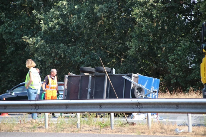 Auto met aanhanger gekanteld