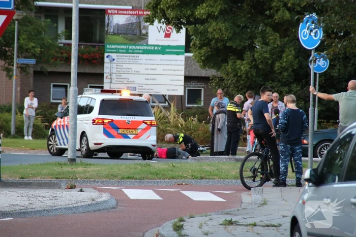 Wielrenster van haar fiets gereden op rotonde