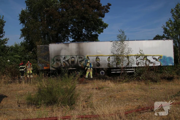 Brand nabij oude trailer in weiland