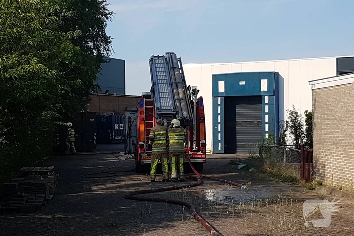 Brand nabij oude trailer in weiland