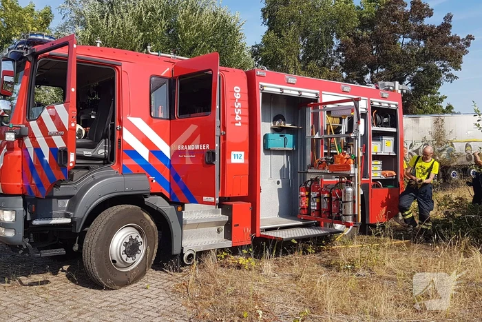 Brand nabij oude trailer in weiland
