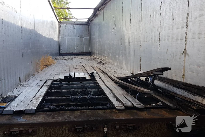 Brand nabij oude trailer in weiland
