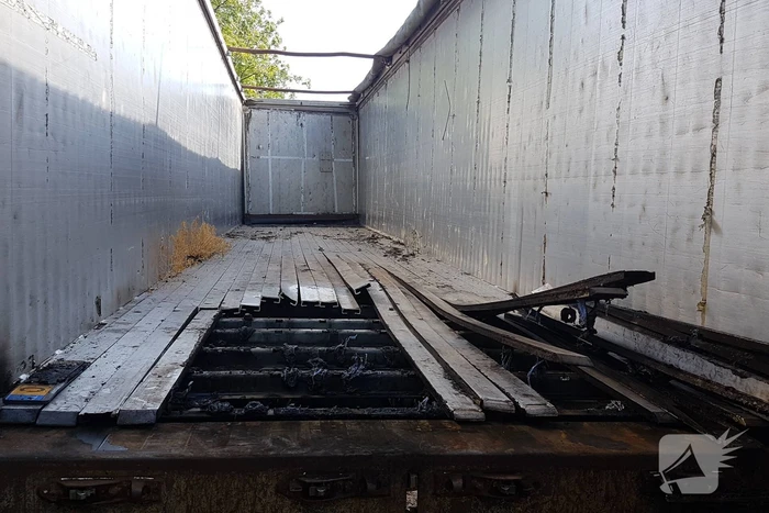 Brand nabij oude trailer in weiland