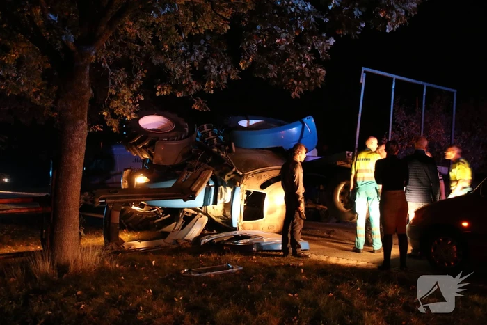 Trekker met aanhanger geschaard en gekanteld