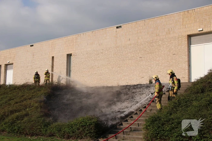 Groenstrook tegen sporthal in brand gestoken