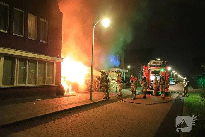 Auto in lichterlaaie onder carport van woning