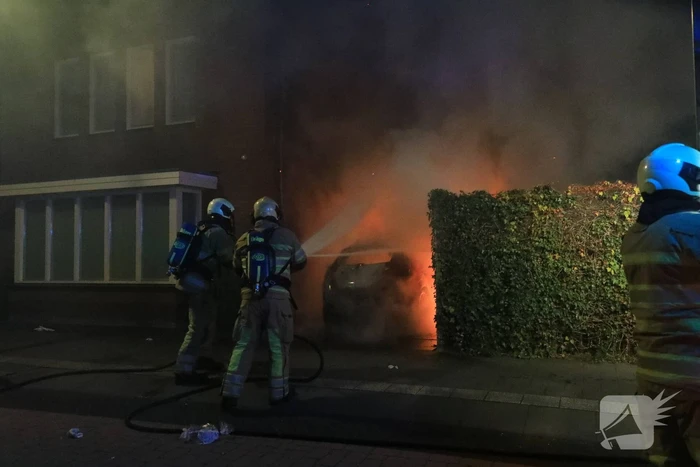 Auto in lichterlaaie onder carport van woning