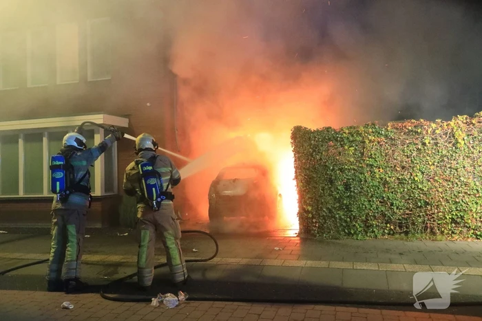 Auto in lichterlaaie onder carport van woning