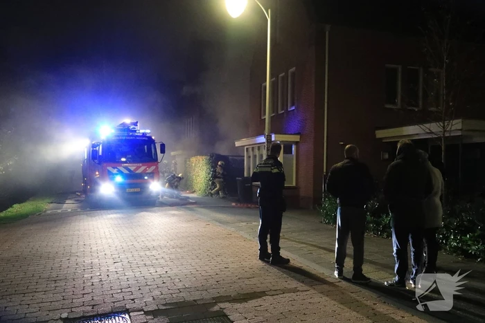 Auto in lichterlaaie onder carport van woning