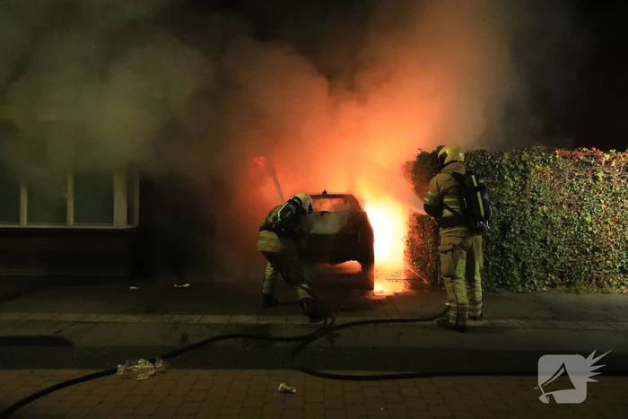 Auto in lichterlaaie onder carport van woning