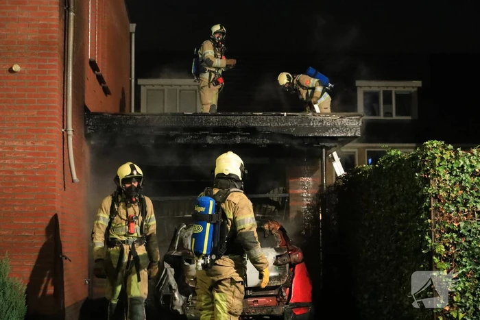 Auto in lichterlaaie onder carport van woning