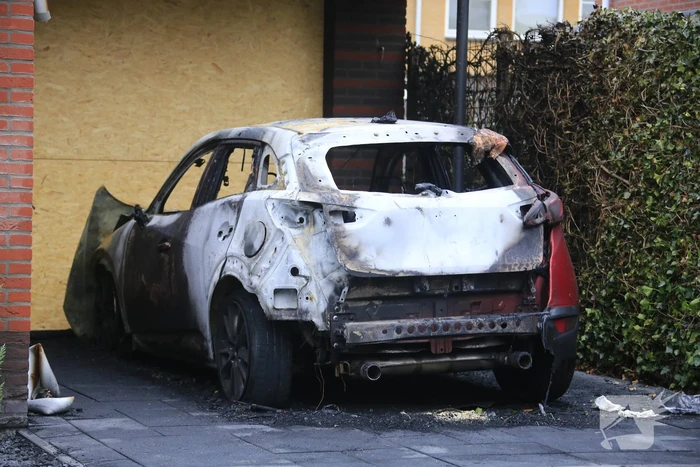 Auto in lichterlaaie onder carport van woning