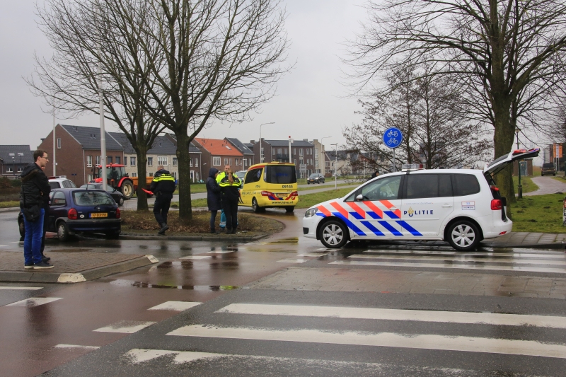Auto en scooter botsen op rotonde