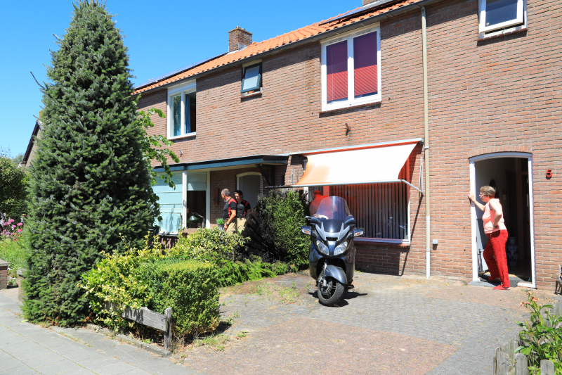 Onkruidbrander zet heg en zonnenscherm in brand