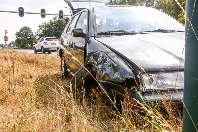 Automobilist vliegt over vluchtheuvel en ramt stoplicht