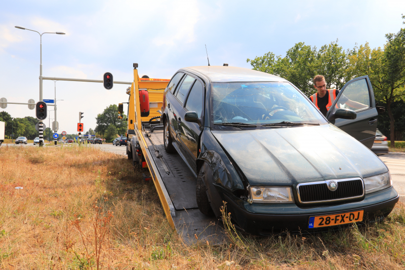 Automobilist vliegt over vluchtheuvel en ramt stoplicht