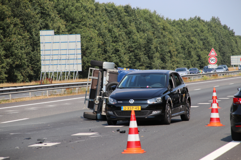 Auto met aanhanger gekanteld