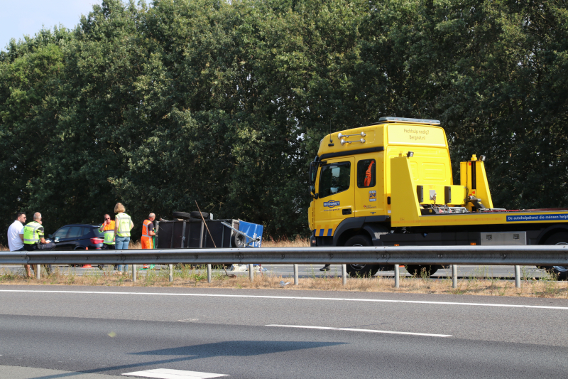 Auto met aanhanger gekanteld