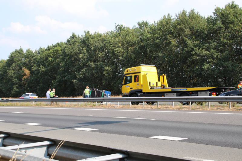 Auto met aanhanger gekanteld