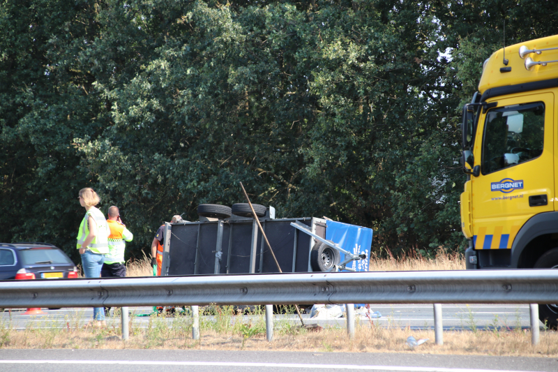 Auto met aanhanger gekanteld