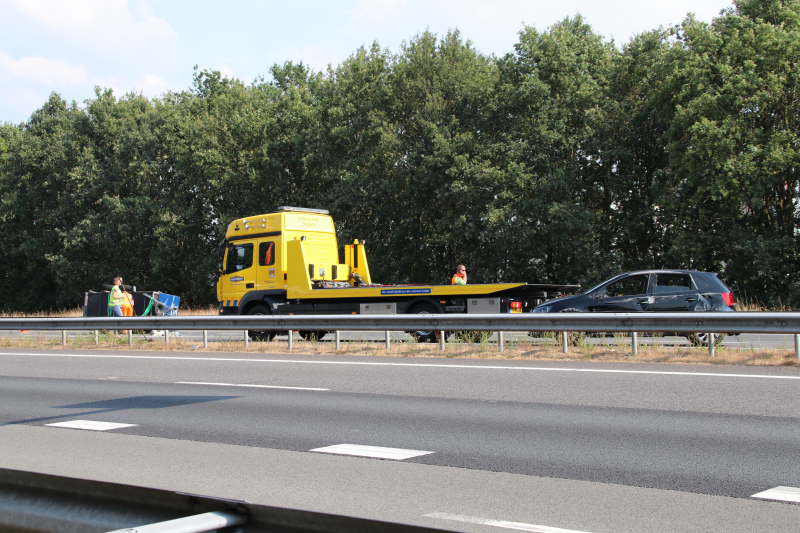 Auto met aanhanger gekanteld