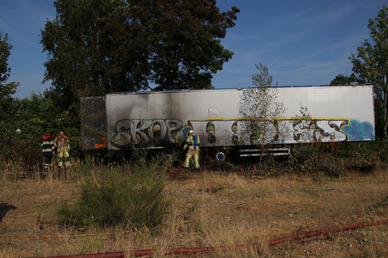 Brand nabij oude trailer in weiland