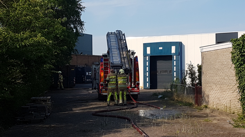 Brand nabij oude trailer in weiland