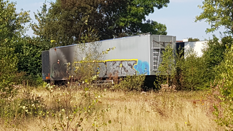 Brand nabij oude trailer in weiland