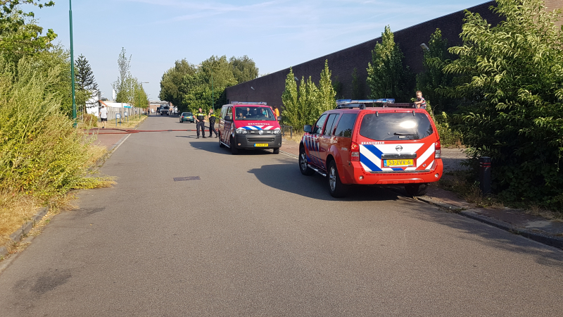 Brand nabij oude trailer in weiland