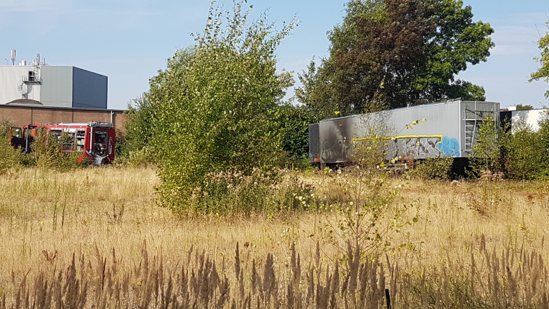 Brand nabij oude trailer in weiland