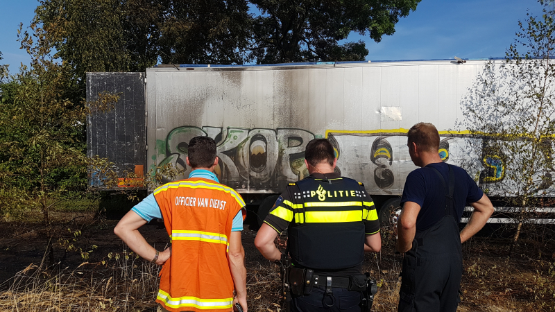 Brand nabij oude trailer in weiland