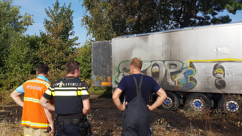 Brand nabij oude trailer in weiland