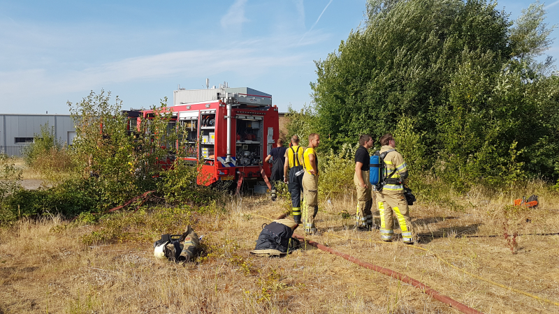 Brand nabij oude trailer in weiland