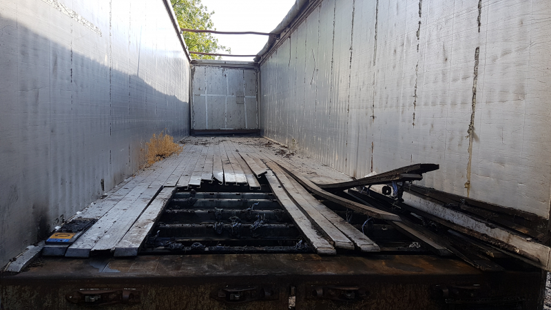 Brand nabij oude trailer in weiland