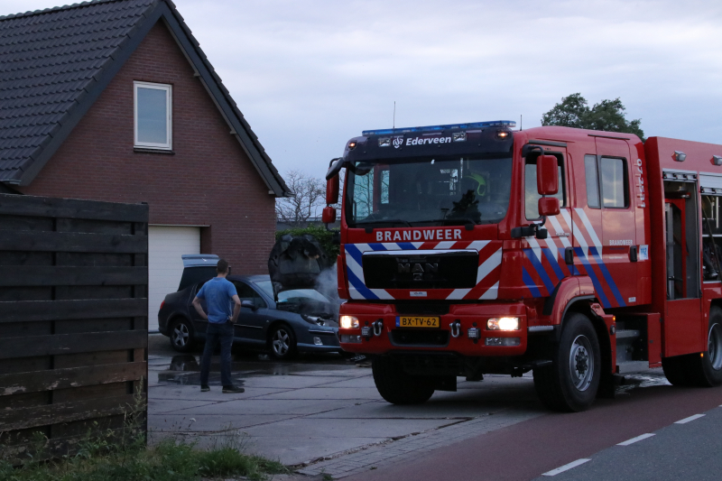 Auto vat vlam voor de garage