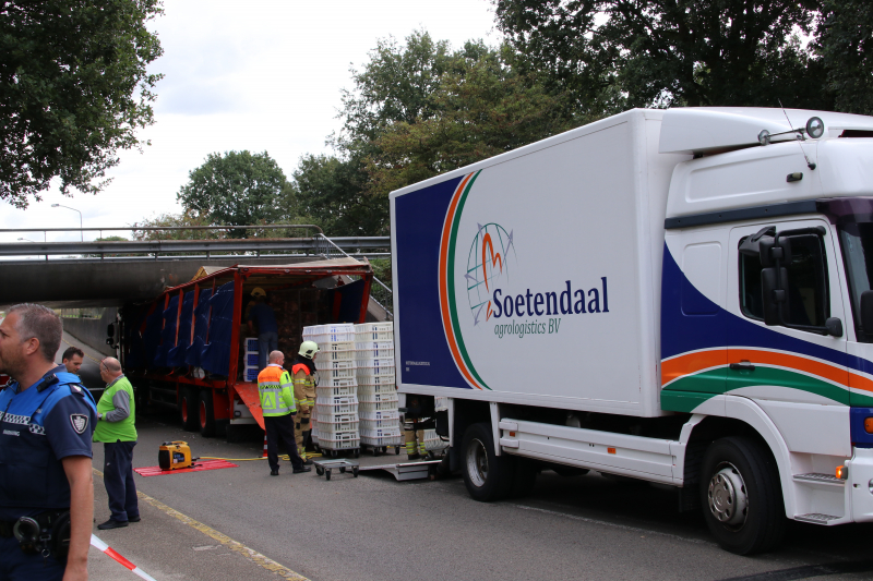 Vrachtwagen vol kippen vastgereden onder viaduct A30
