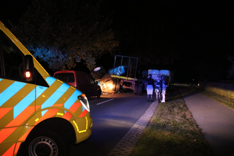 Trekker met aanhanger geschaard en gekanteld