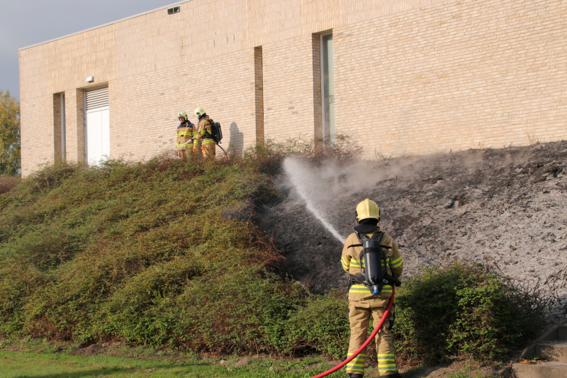Groenstrook tegen sporthal in brand gestoken