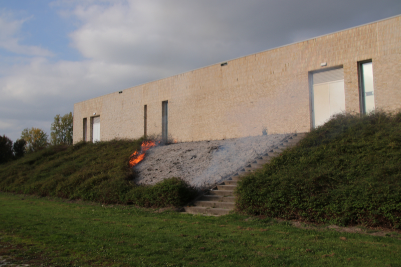 Groenstrook tegen sporthal in brand gestoken