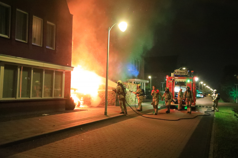 Auto in lichterlaaie onder carport van woning