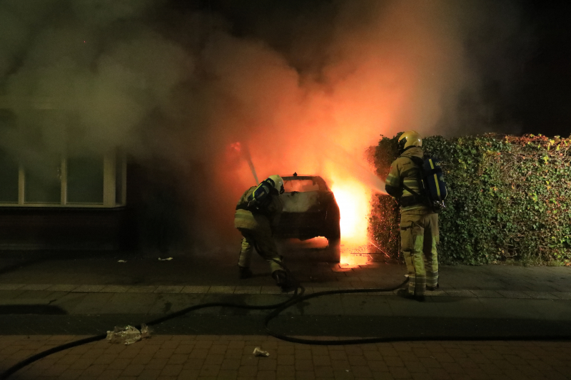 Auto in lichterlaaie onder carport van woning