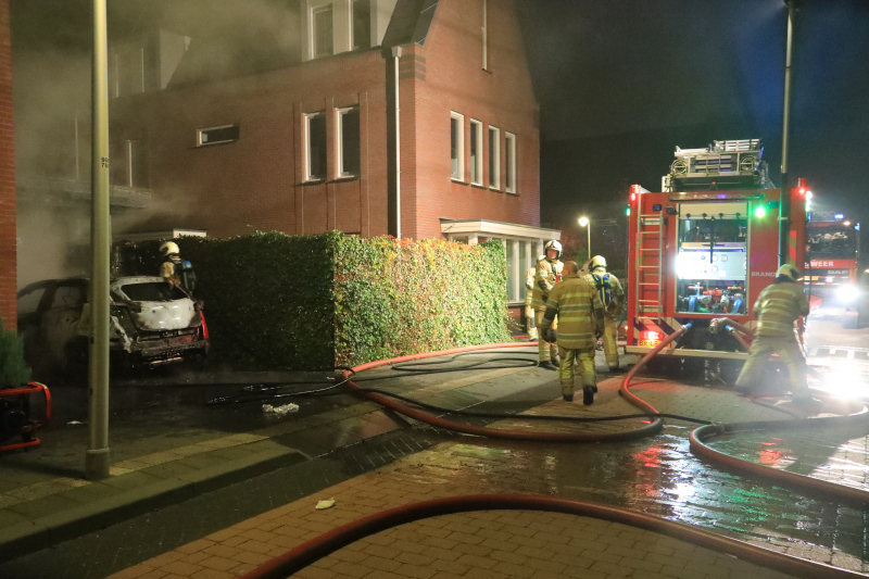 Auto in lichterlaaie onder carport van woning