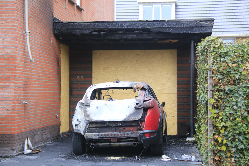 Auto in lichterlaaie onder carport van woning