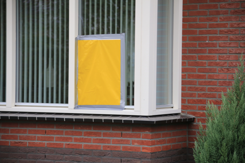 Auto in lichterlaaie onder carport van woning